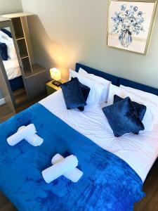 BuckinghamshireTown Center Retreat 2 Bed Gem with Free Parking and Garden的一张带蓝色毯子和拖鞋的床