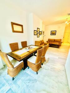 贝纳尔马德纳Apartamento Playa Torrequebrada Coloso的一间带木桌和藤椅的用餐室