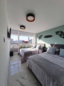 墨西哥城Bright APT w/view near Reforma的一间卧室设有两张床和大窗户