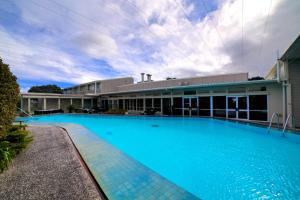 惠灵顿布伦特伍德酒店的大楼前的大型蓝色游泳池