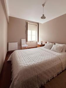 维亚纳堡Apartment Vedória的卧室配有一张大白色床和窗户