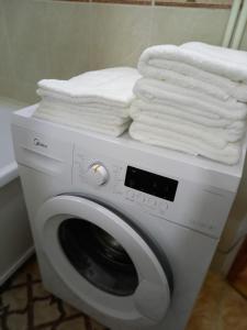 阿克托比ОРАНЖЕВЫЙ МИР的洗衣机及其上面的毛巾