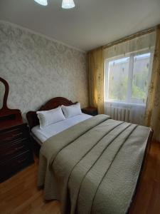 阿克托比ОРАНЖЕВЫЙ МИР的一间卧室设有一张大床和一个窗户。