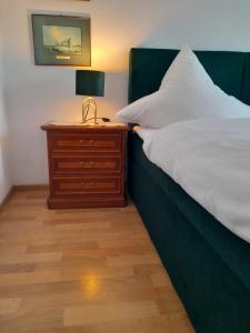 温特里希Gästehaus Föhr的一间卧室配有一张床和一个带灯的床头柜