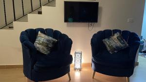 艾因苏赫纳فيلا في بلو باي أسيا العين السخنة的客厅设有两把椅子,配有电视