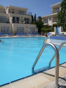 波利斯拉奇一室公寓的酒店设有一个大型游泳池,游泳池内摆放着蓝色的椅子