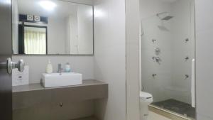 马萨特兰圣路易斯套房公寓的浴室配有卫生间、盥洗盆和淋浴。