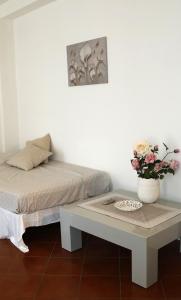 里乔内BlancoHouse Viale Ceccarini的一间设有一张床和一张花瓶桌子的房间