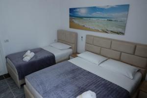 维利波吉Fishta apartments Q5 32的一间卧室配有两张床,享有海滩美景。