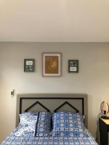 OuanganiChez Mkoudou的卧室配有一张墙上三幅照片的床