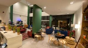 艾卜哈ريف سويت للأجنحة الفندقية的大堂设有桌椅和绿色柱子