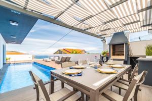 丰沙尔Belle Maison I by Madeira Sun Travel的一间带桌子和游泳池的用餐室