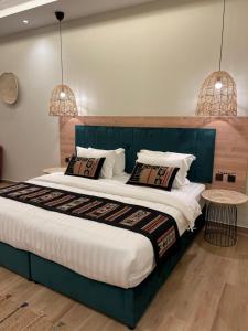 艾卜哈ريف سويت للأجنحة الفندقية的一间卧室配有一张大床和两个吊灯
