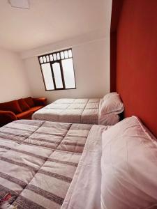 阿亚库乔Castellares la Puebla Hostelería Departamento的一间卧室设有两张床和窗户。