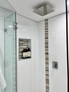 悉尼Bondi Beach Waves Beachfront Apartment的带淋浴的浴室和玻璃门