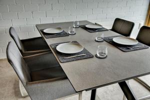 LichtenbergChalet Alba的桌子上摆放着椅子和盘子,玻璃杯