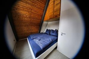 LichtenbergChalet Alba的一间设有蓝色床和木墙的小卧室