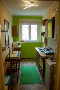 埃格尔Foxy Apartman的绿色的厨房,配有桌子和窗户