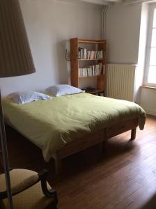 Chambres d'hôtes au calme的一间卧室设有一张床和一个书架
