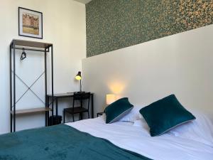 图尔Hotel TULTY的一间卧室配有一张大床和两个绿色枕头