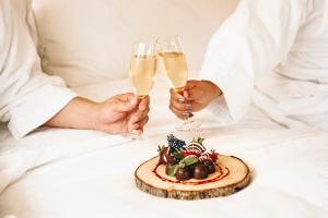 圣地亚哥圣地亚哥福朋喜来登酒店的两人拿着香槟酒杯和一盘食物