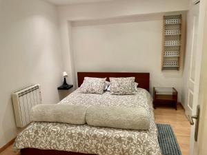 马德里Acogedor Dúplex Barrio del Pilar的一间卧室配有一张带棕色床头板和枕头的床。