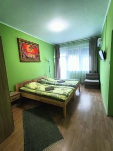 鲍洛通塞派兹德橡树旅馆的一间设有两张床的卧室,位于带绿色墙壁的房间