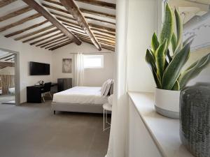 斯培西亚New Moon Rooms的一间卧室配有一张床和盆栽植物