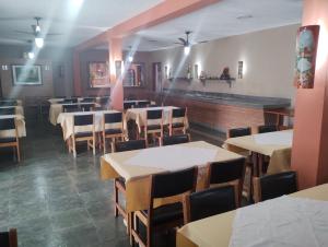 若阿诺波利斯Pousada Solar das Palmeiras的餐厅用餐室配有桌椅