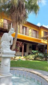彼得罗波利斯Hotel Vila Bavária的一座棕榈树建筑前的雕像