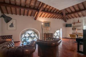 佩鲁贾Umbrian Concierge - Cozy Loft Vannucci的客厅配有皮革家具和拱门