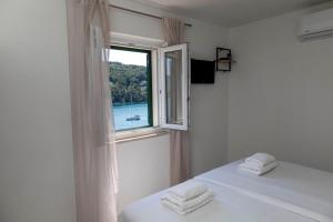 普契什查Lučica, Luxury Rooms By the Sea的一间卧室配有床和带毛巾的窗户。