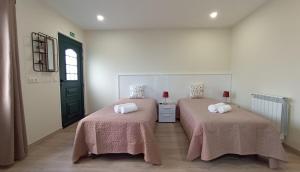 桑塔纳A Toca的一间设有两张粉红色毯子的床的房间