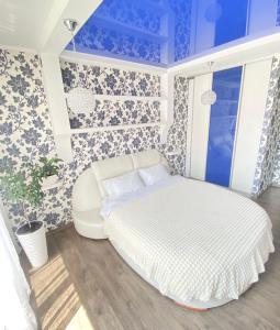 切尔诺夫策Zoryaniy Apartments City ПРОСТОРА та затишна НОВОБУДОВА біля парку Шевченка та ЦЕНТРУ的卧室配有白色的床和蓝色的墙壁