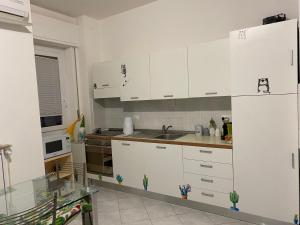 拉帕洛Polly的厨房配有白色橱柜和水槽