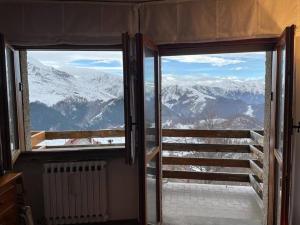 普拉托讷沃斯Monolocale Bellavista的开放式门,享有雪覆盖的山脉美景