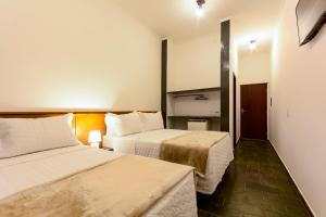 阿瓜斯迪林多亚Hotel Fazenda Aguas de Lindoia的一间酒店客房,房间内设有两张床