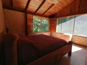 明多La Chonta的一间设有床铺的卧室,位于带窗户的房间内