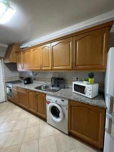 西尔韦斯Apartamento Xelb的厨房配有洗衣机和微波炉。