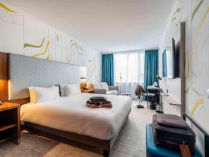 安特卫普Mercure Antwerp City Centre的酒店客房设有一张大床和一张书桌。