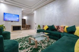 卡萨布兰卡Appartement spacieux avec piscine à Dar Bouazza - Casablanca的客厅配有绿色沙发和电视