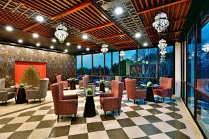 斯利那加斯利那加福朋喜来登酒店的餐厅设有桌椅和窗户。