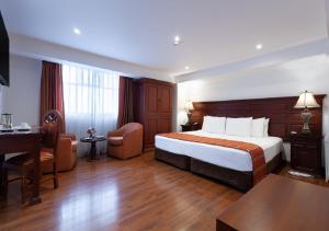 库斯科泰拉安迪纳殖民地庄园酒店的配有一张床和一张书桌的酒店客房