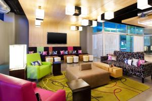 坎昆雅乐轩坎昆酒店的大堂配有色彩缤纷的家具和平面电视。