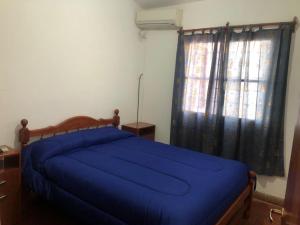 萨尔塔La escondida的一间卧室设有蓝色的床和窗户。