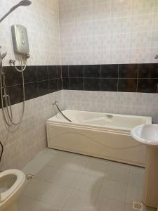 MacangKOTOKOH INN的带浴缸、卫生间和盥洗盆的浴室