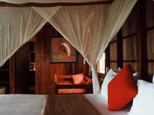 TapokrengRaja Ampat Eco Lodge的一间卧室配有带窗帘的床和椅子