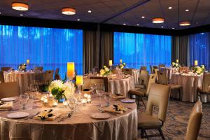 圣地亚哥拉霍亚喜来登酒店的宴会厅配有桌椅和白色的桌布