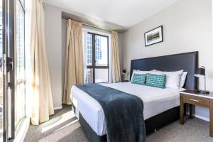 奥克兰女王大街奎斯特服务公寓的一间卧室设有一张床和一个大窗户