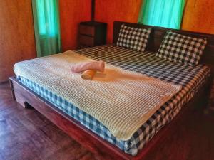特特巴图Pondok rinjani bungalow tetebatu的一张大床,上面有木脚板